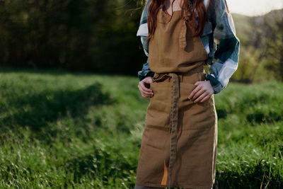 Midsection of woman standing on field