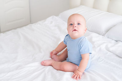 Cute baby boy sleeping on bed at home