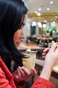 Profile view of woman eating sweet food in restaurant