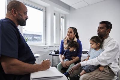 Male doctor talking to family with children