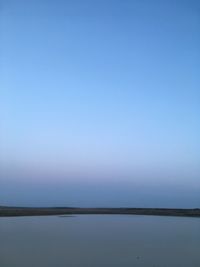 Scenic view of water against clear blue sky