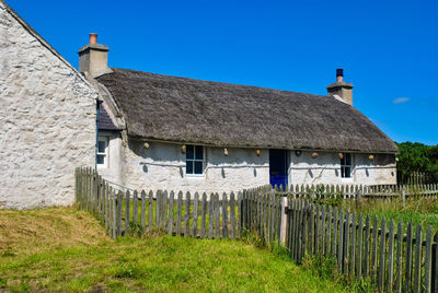 House on field against blue sky