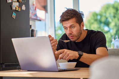 Young man using laptop at table