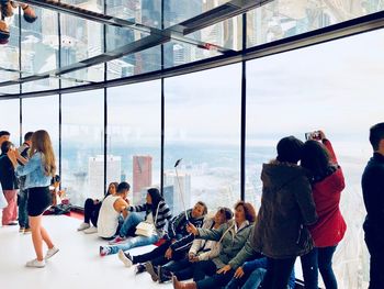 Group of people standing by window in city