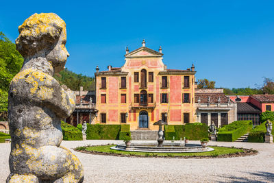 Statue of historic building against blue sky