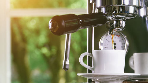 Close-up of coffee pouring in cup