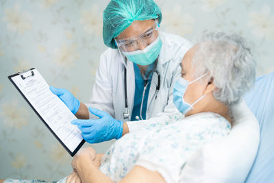 Doctor showing medical record to patient at hospital