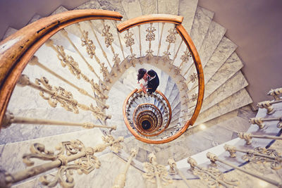 High angle view of couple standing on spiral stairs