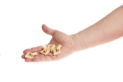 Close-up of hand holding ice cream over white background