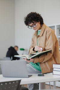 Young woman using laptop while sitting at table