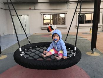 Full length of boy sitting in swing