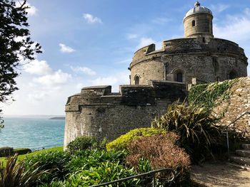 View of historical building by sea against sky