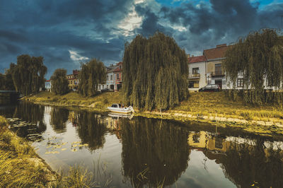 Scenic view of lake by buildings against sky