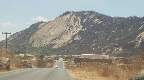 Road amidst mountains against sky