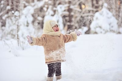 Cute girl playing on snowfield