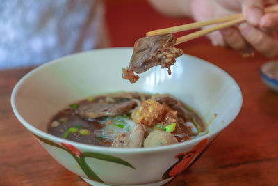 Close-up of hand holding food in bowl