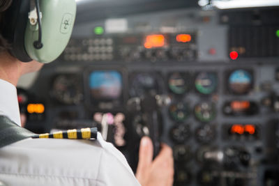 Midsection of pilot controlling cockpit in airplane