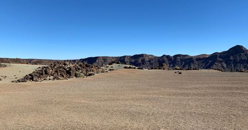 Panoramic view of desert landscape against clear blue sky