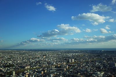 Aerial view of cityscape against blue sky