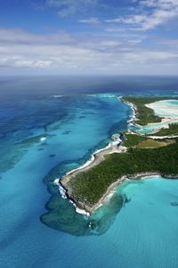 Aerial view of land by sea against sky