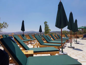 Empty chairs and tables against clear blue sky