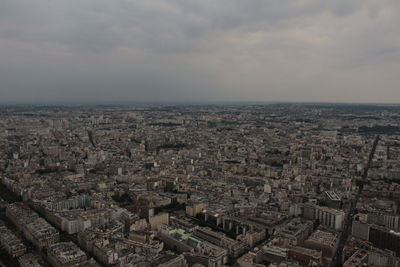 High angle view of city buildings against cloudy sky