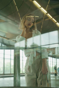 Young woman looking through glass in moscow open metro station 