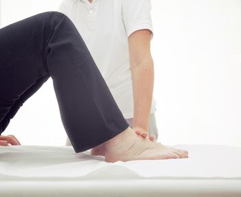 Low section of woman standing against white background
