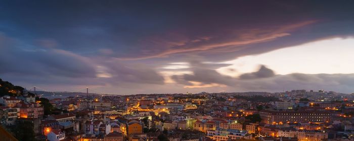 High angle view of illuminated cityscape against sky at sunset