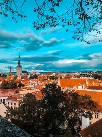 View of buildings in city against cloudy sky