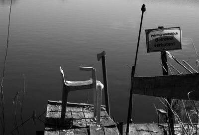 Abandoned chair on pier over lake