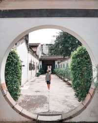 Rear view of woman standing by building