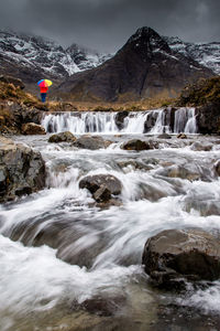 Scenic view of waterfall against mountain