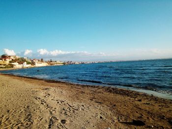 Scenic view of beach against clear blue sky