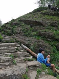 Men sitting on rock in forest