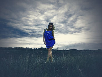 Full length of woman standing on field against sky