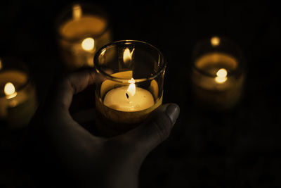 Human hand holding lit candle