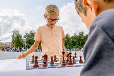  children playing chess game outdoors in the city 