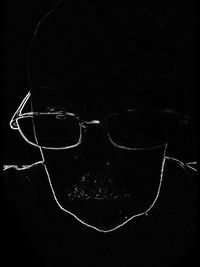 Portrait of man wearing sunglasses against black background