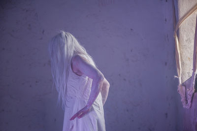 Woman performing by window in abandoned building