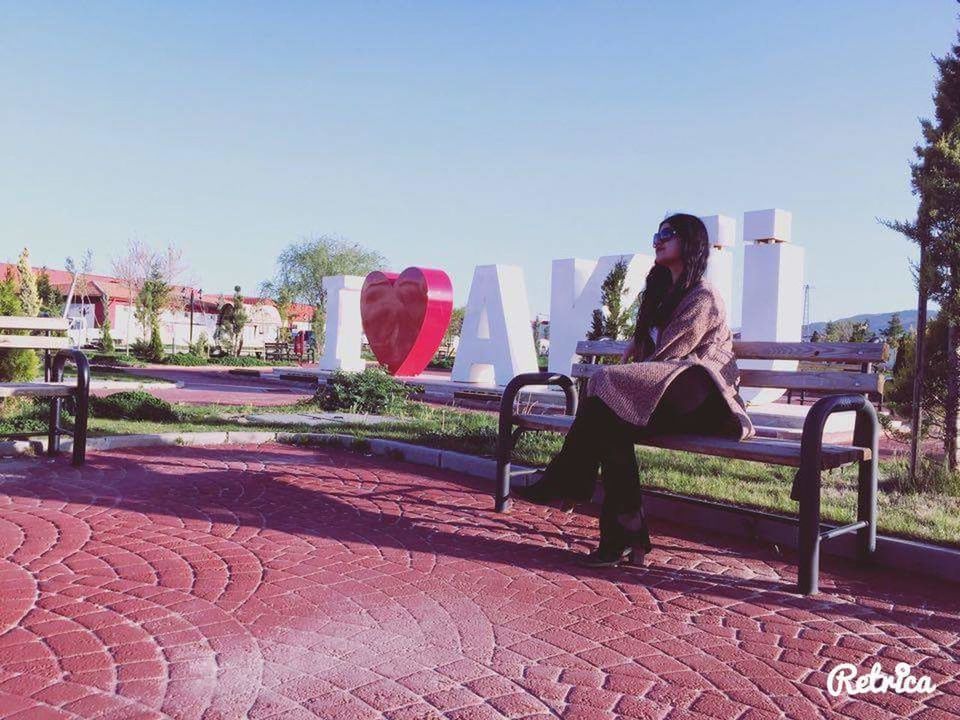 clear sky, tree, lifestyles, leisure activity, copy space, sitting, sunlight, person, park - man made space, bench, outdoors, day, chair, relaxation, sky, built structure, men, incidental people