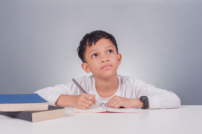 Portrait of boy sitting on table