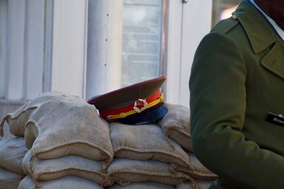 Midsection of man with cap on sack heap