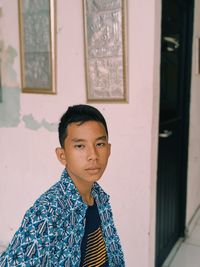 Portrait of young man standing at home