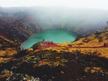 High angle view of people at kerid in volcanic crater during foggy weather