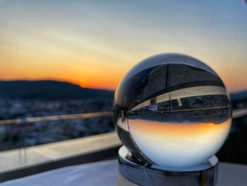 Close-up of crystal ball against sky during sunset