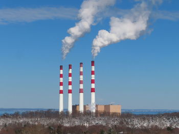 Smoke emitting from chimney against sky