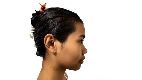 Portrait of young woman looking away against white background