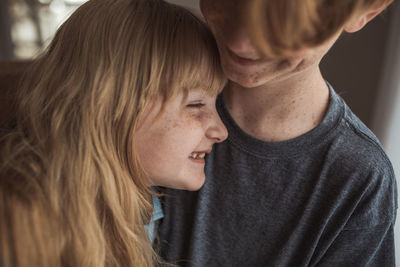 Close up of of young freckled girl with older brother