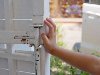 Close-up of hand touching door